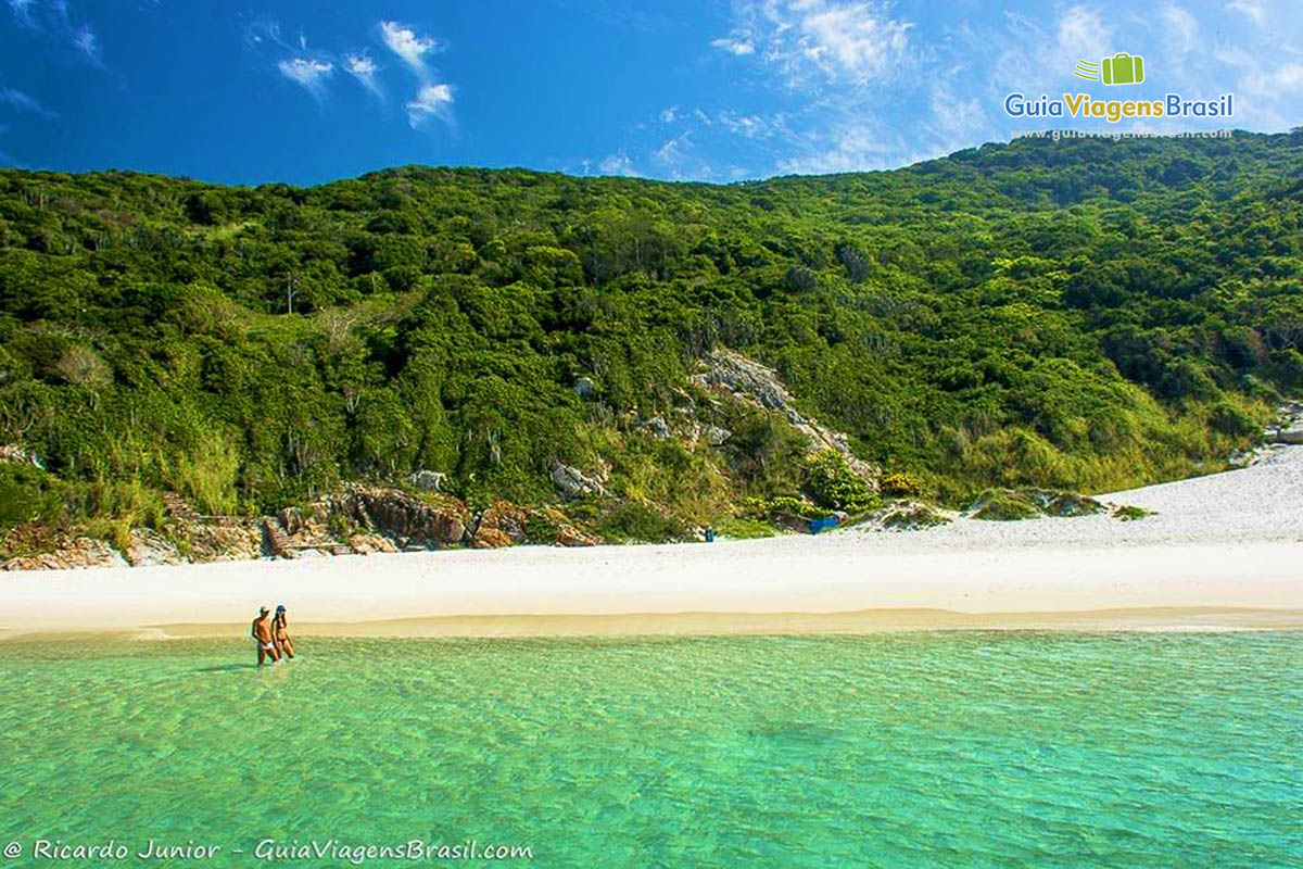 Imagem de casal caminhando na lindíssima Praia Pontal do Atalaia.