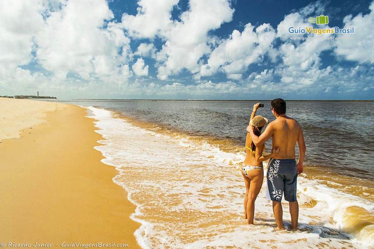 Imagem de casal fazendo uma selfie na Praia do Gunga.