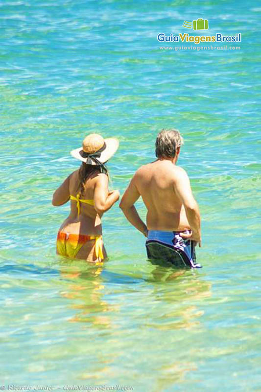 Imagem de um casal nas águas da Praia Lagoinha.