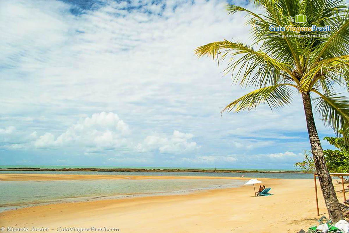 Imagem de um casal sentado nas areias da linda Praia Santo André.