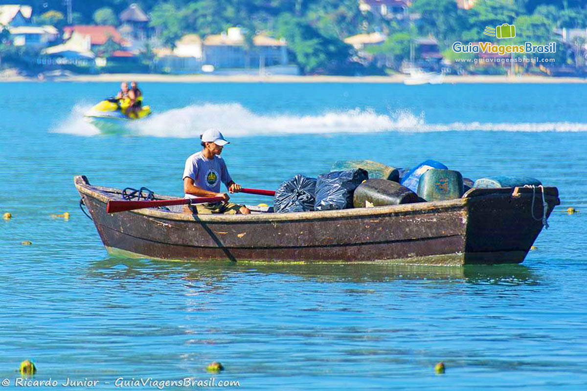 Imagem de catadora de lixo em um barco de pescador.