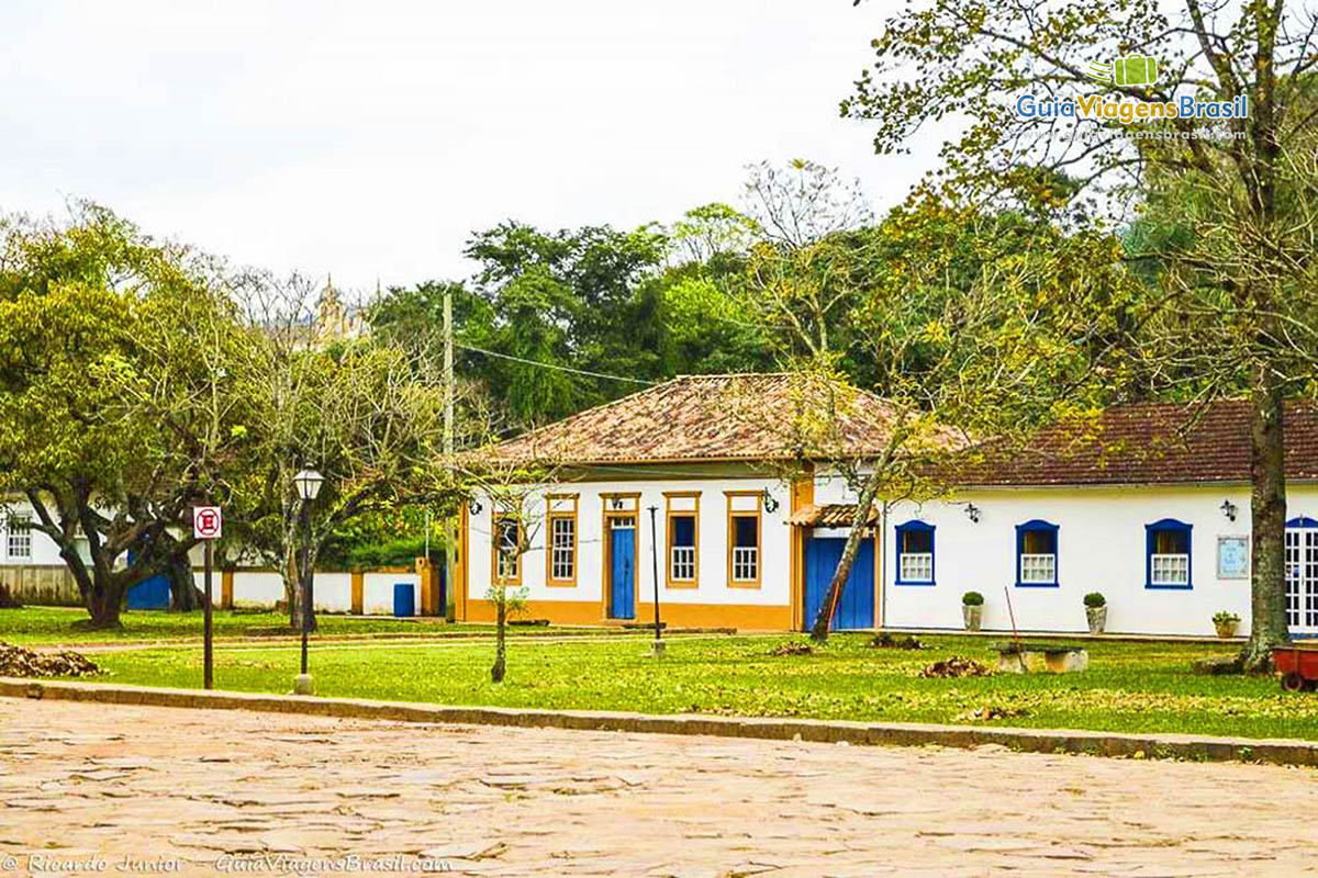 Imagem de ruas calmas de paralelepípedos e calçadas de gramas.