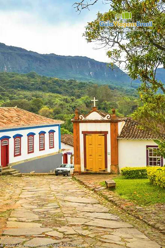 Imagem da pequena praça e ao fundo detalhes da capela.