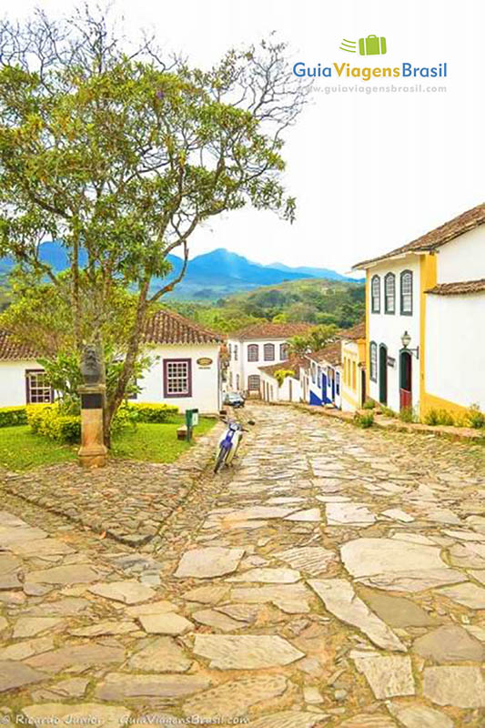 Imagem da charmosa praça e ao lado uma ladeira de paralelepípedo.