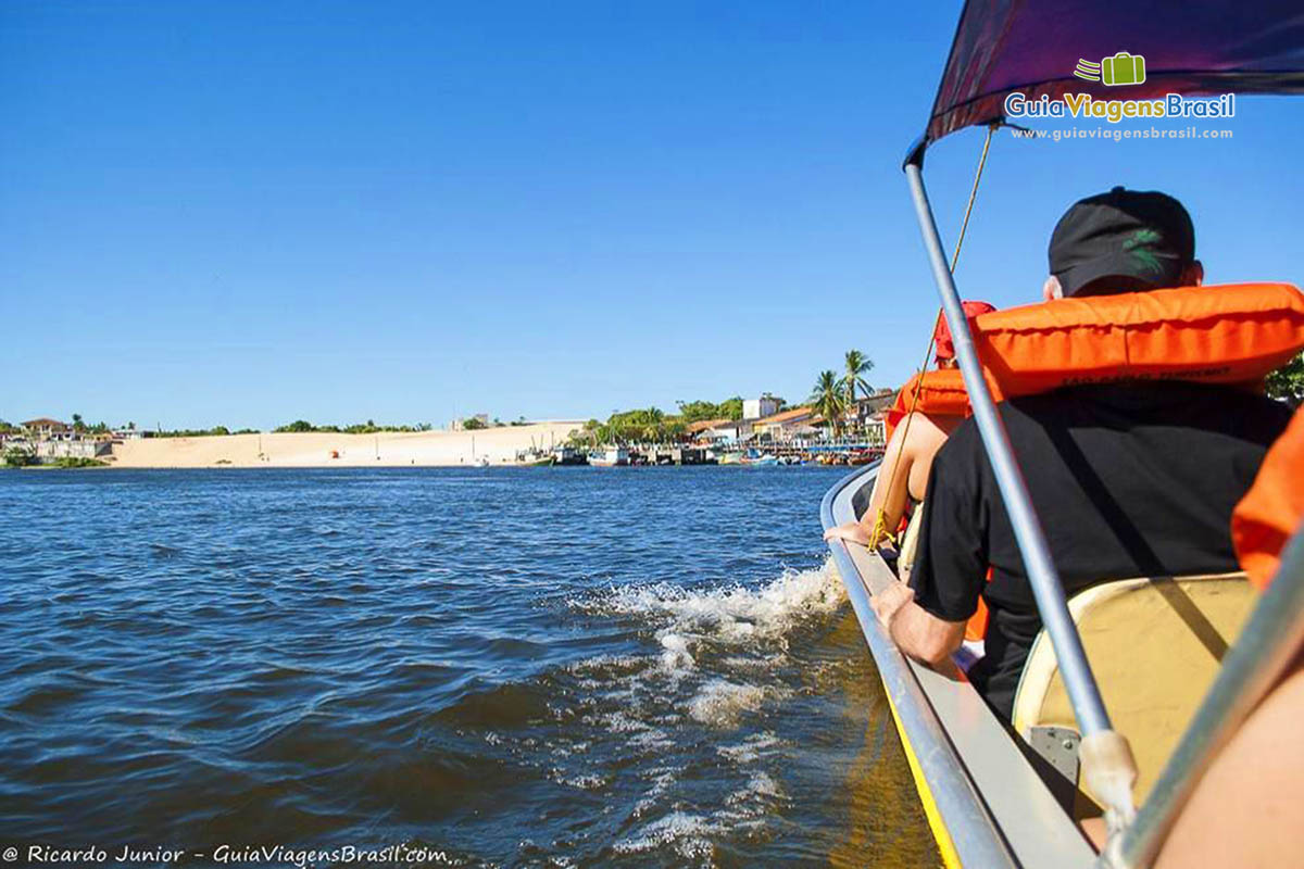 Imagem de turistas com colete salva vidas passeando de barco.