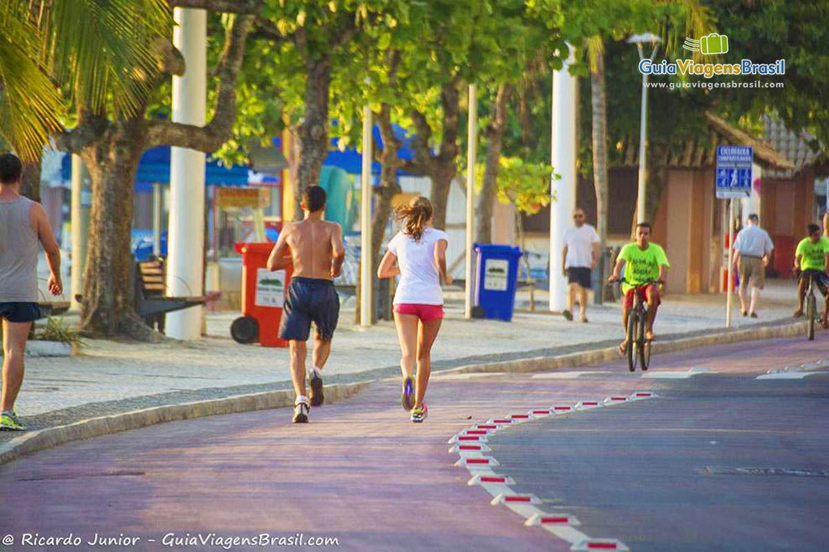 Imagem de um casal correndo no calçadão da praia de Balneário.