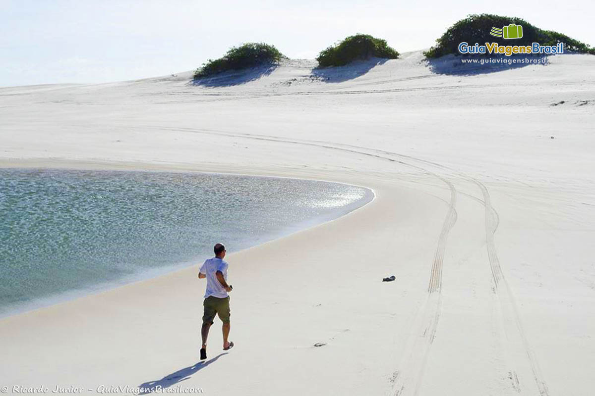 Imagem de um turistas caminhando nas dunas brancas em Santo Amaro.