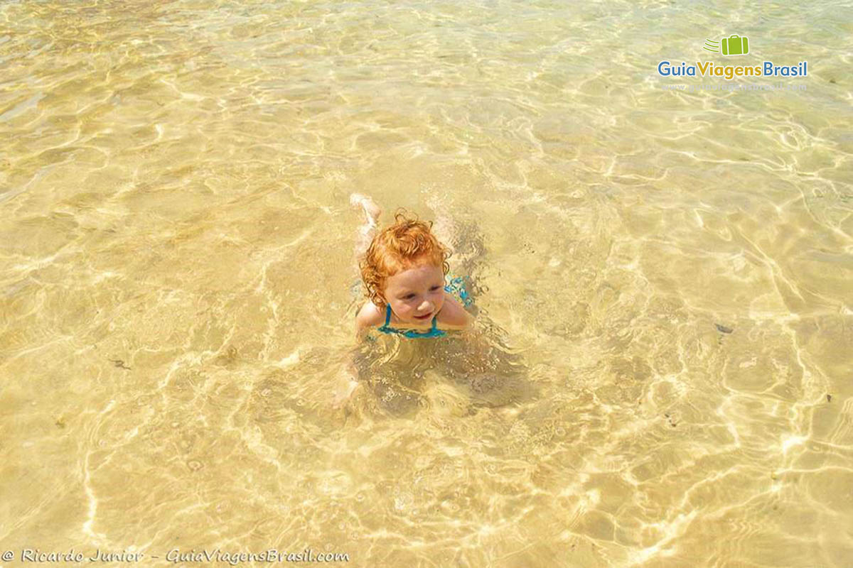 Imagem de uma linda criança mergulhando nas águas transparente da Lagoa Azul.