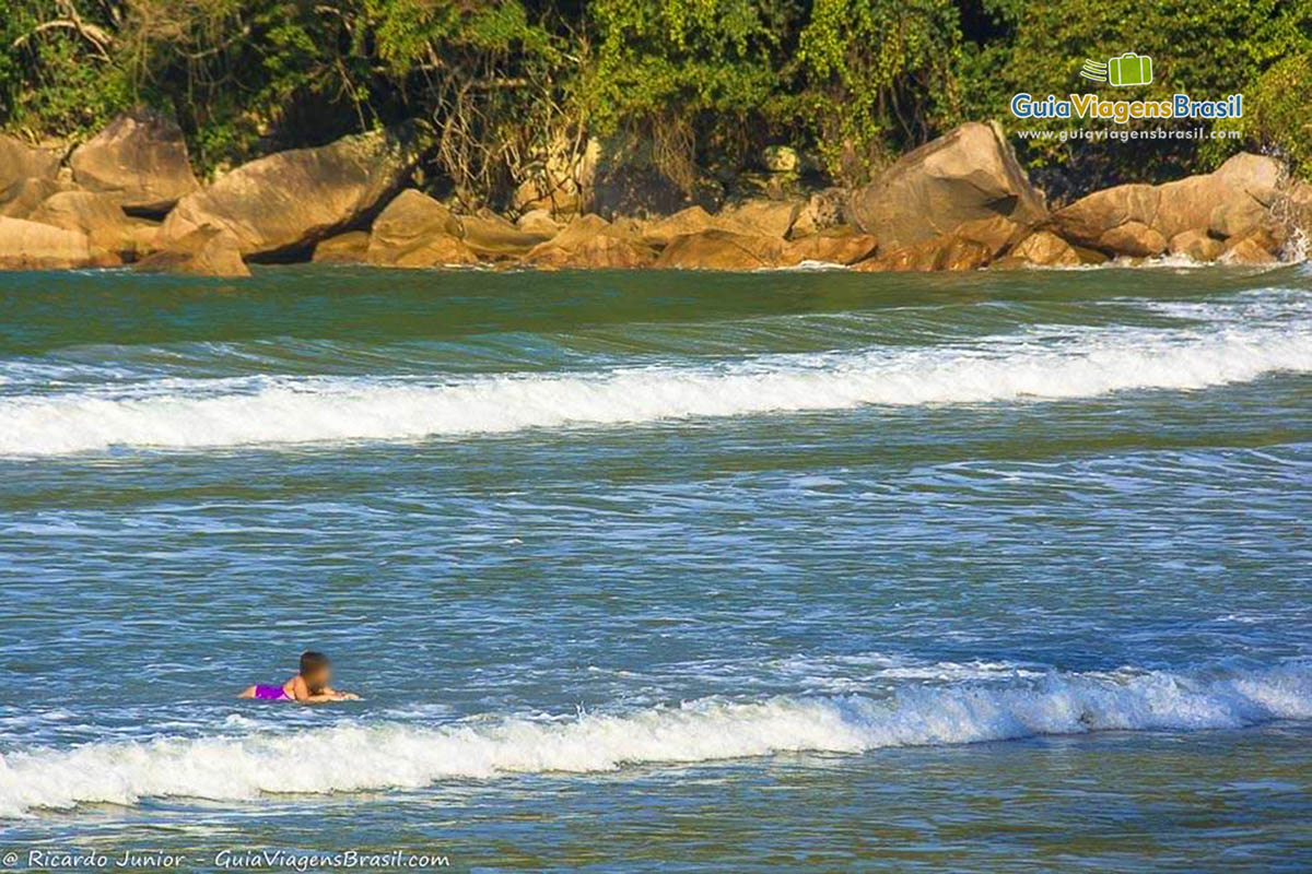 Imagem de uma menina nas águas do mar da Praia das Toninhas.