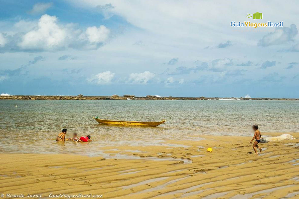 Imagem de família na beira da Praia Barra São Miguel.