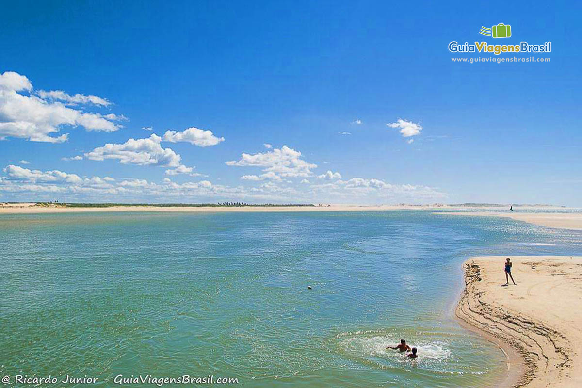 Imagem de crianças aproveitando  nas águas da praia.