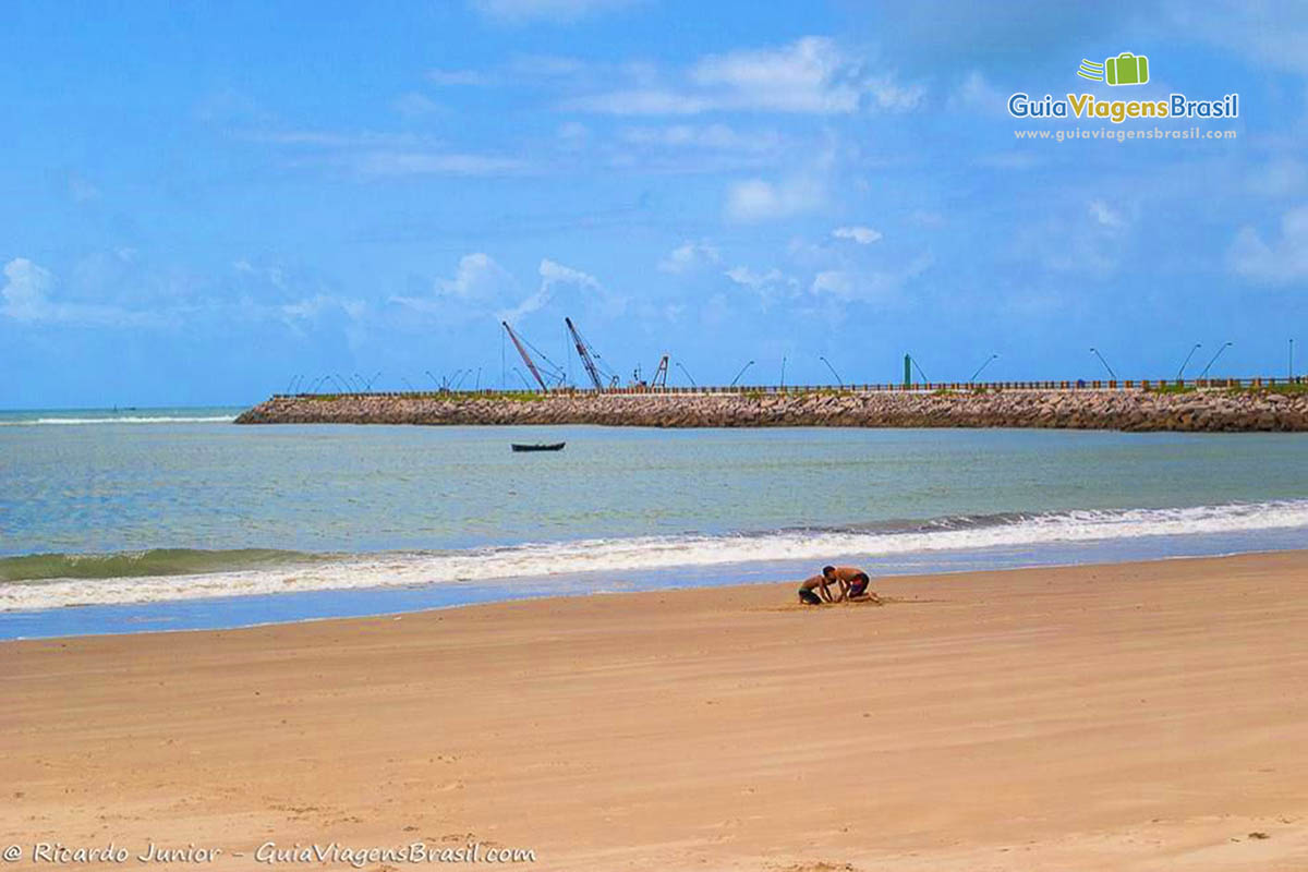 Imagem de crianças brincando na areia da Praia Rendinhas.