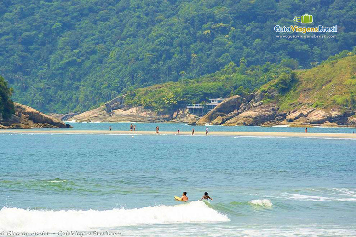 Imagem de crianças surfando na Praia de Pernambuco.