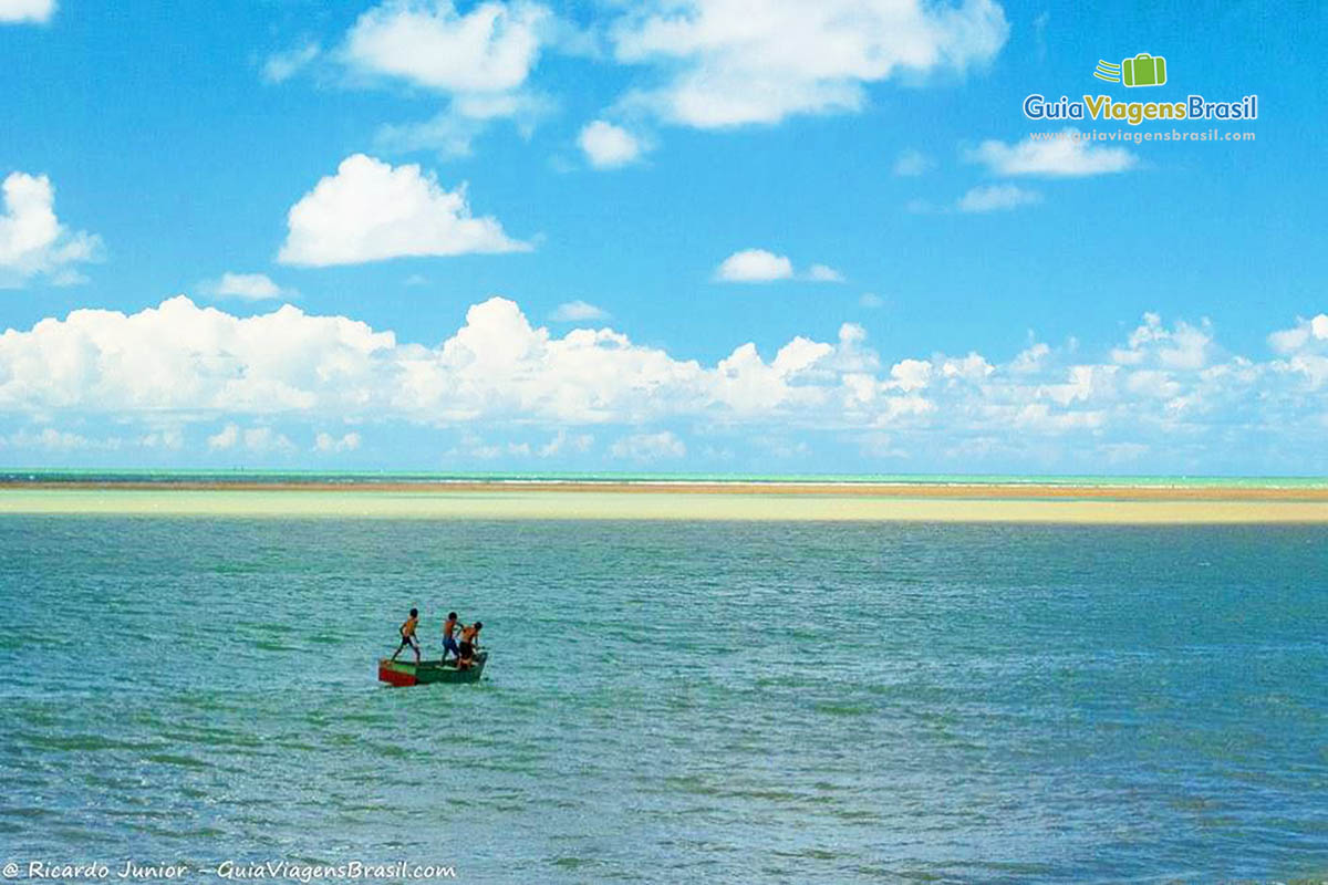 Imagem de crianças brincando nas águas da praia.