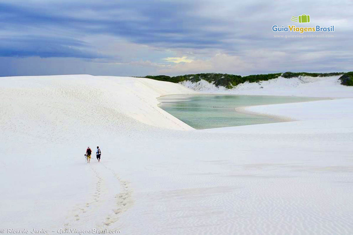 Imagem de duas pessoas caminhando pelas dunas branquinhas do Circuito Lagoa Azul.