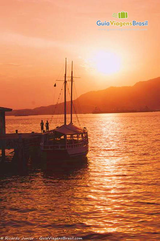 Imagem de um lindo barco e um por do sol fantástico.