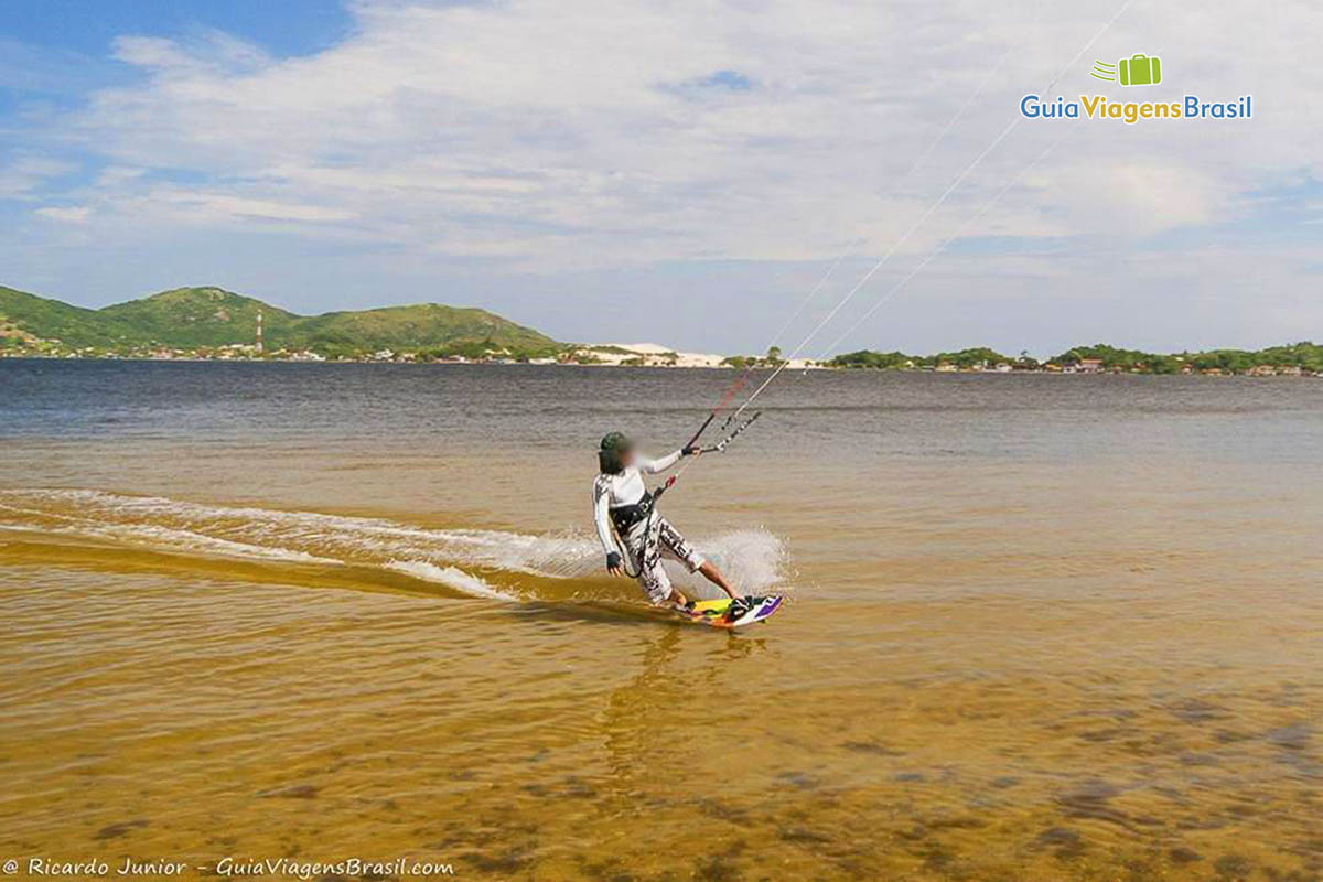 Imagem de uma rapaz praticando esporte na lagoa.