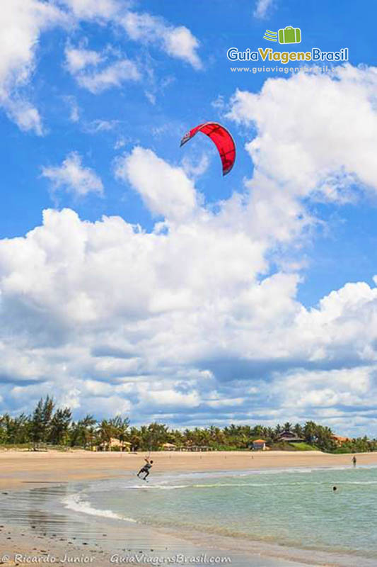 Imagem de uma pessoa praticando kitesurfe na Praia do Coqueiro.