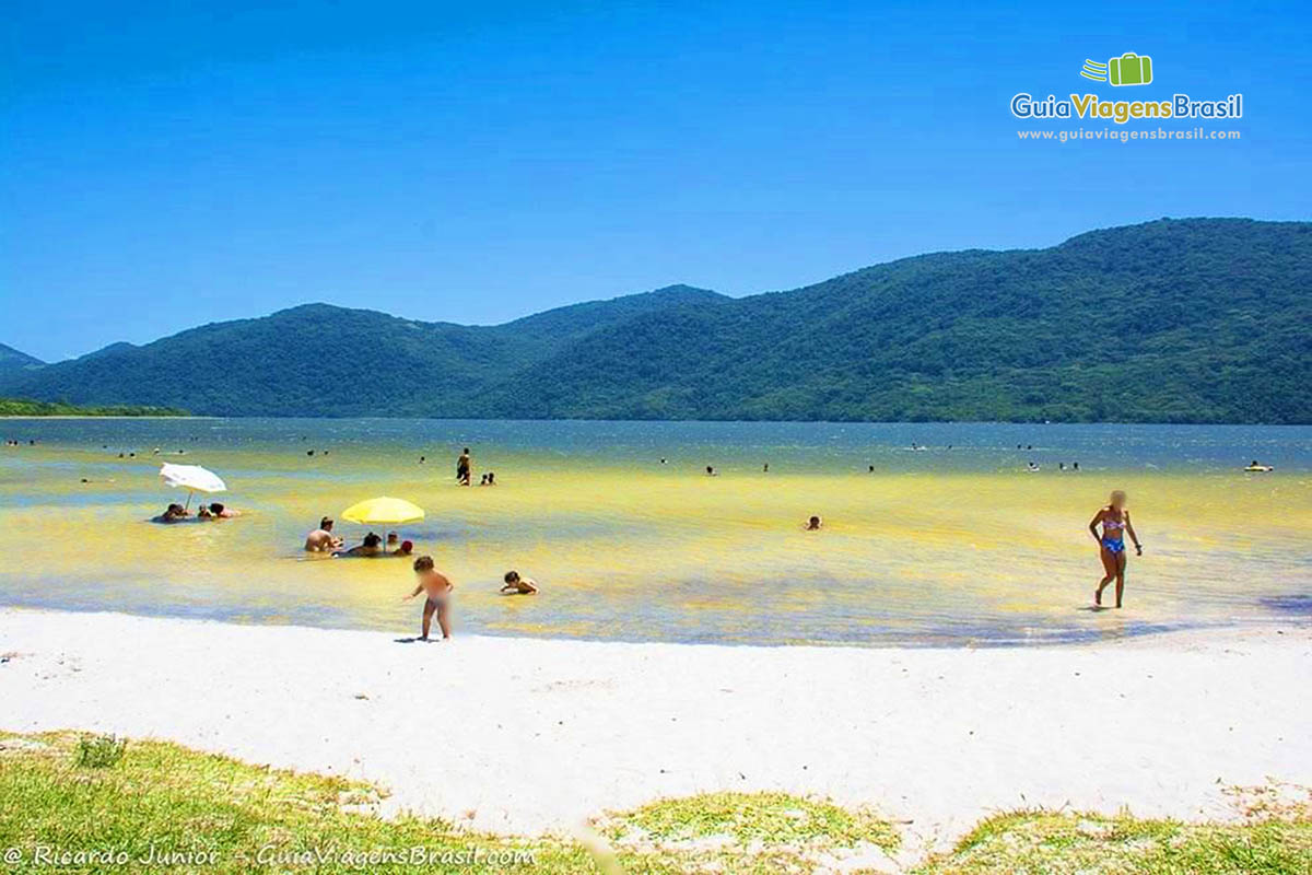 Imagem de famílias aproveitando a tarde de sol na lagoa.