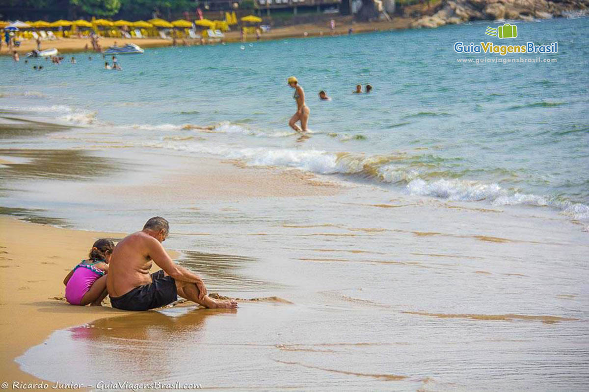 Imagem de família brincando na beira da Praia do Curral.