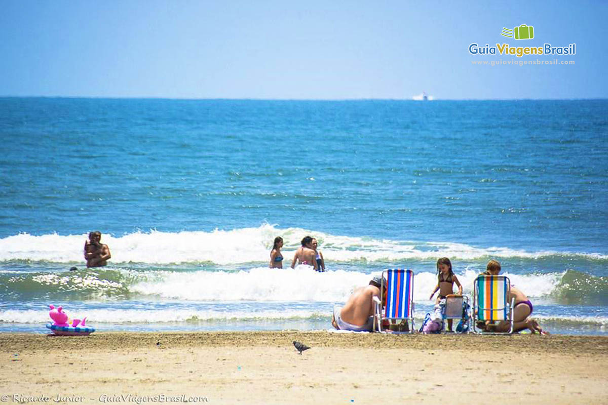 Imagem de famílias aproveitando o lindo dia na praia.