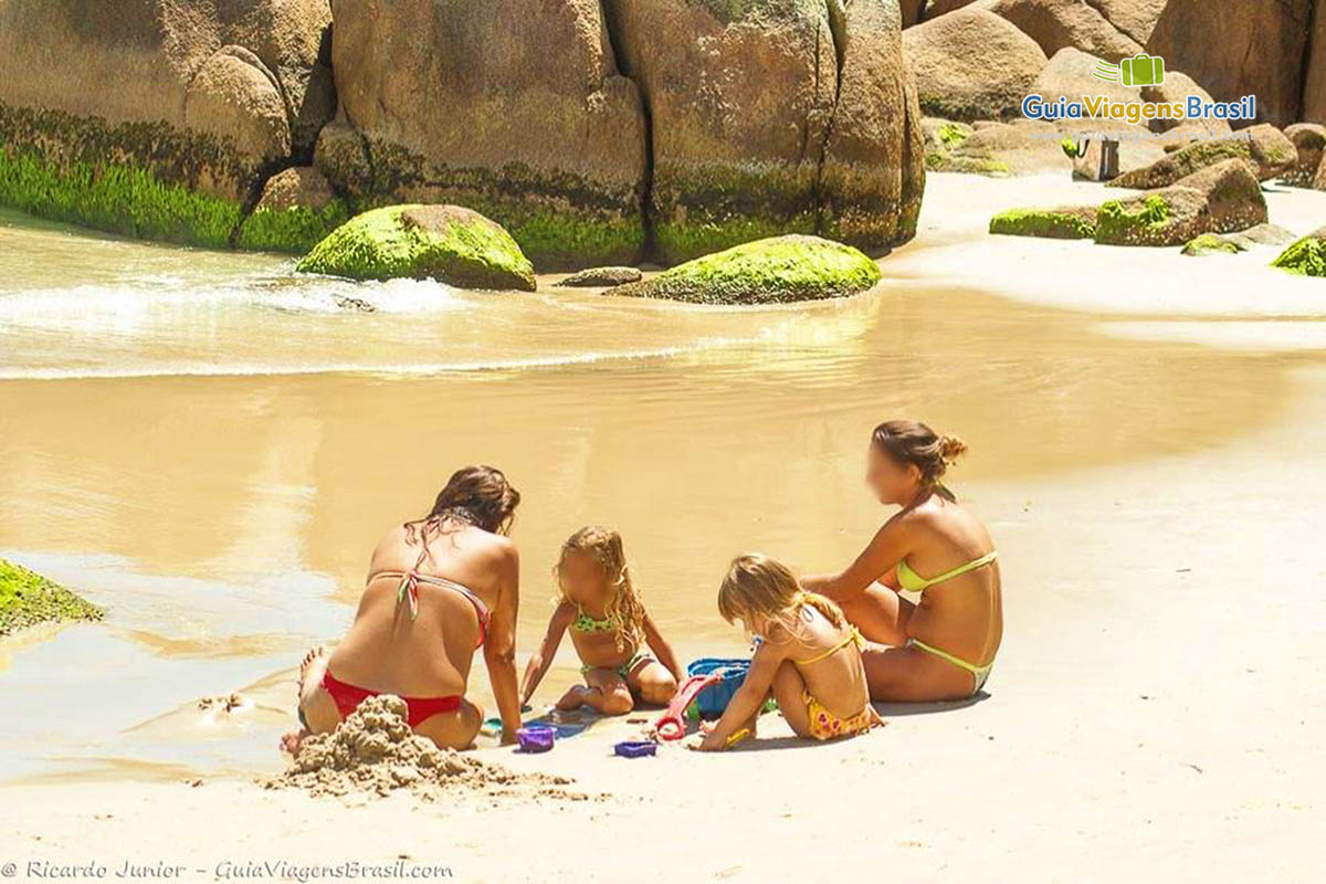 Imagem de uma família brincando nas areias da Praia Lagoinha.