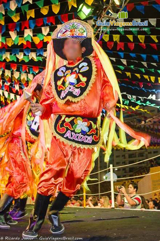 Imagem de um rapaz com uma bela fantasia laranja.