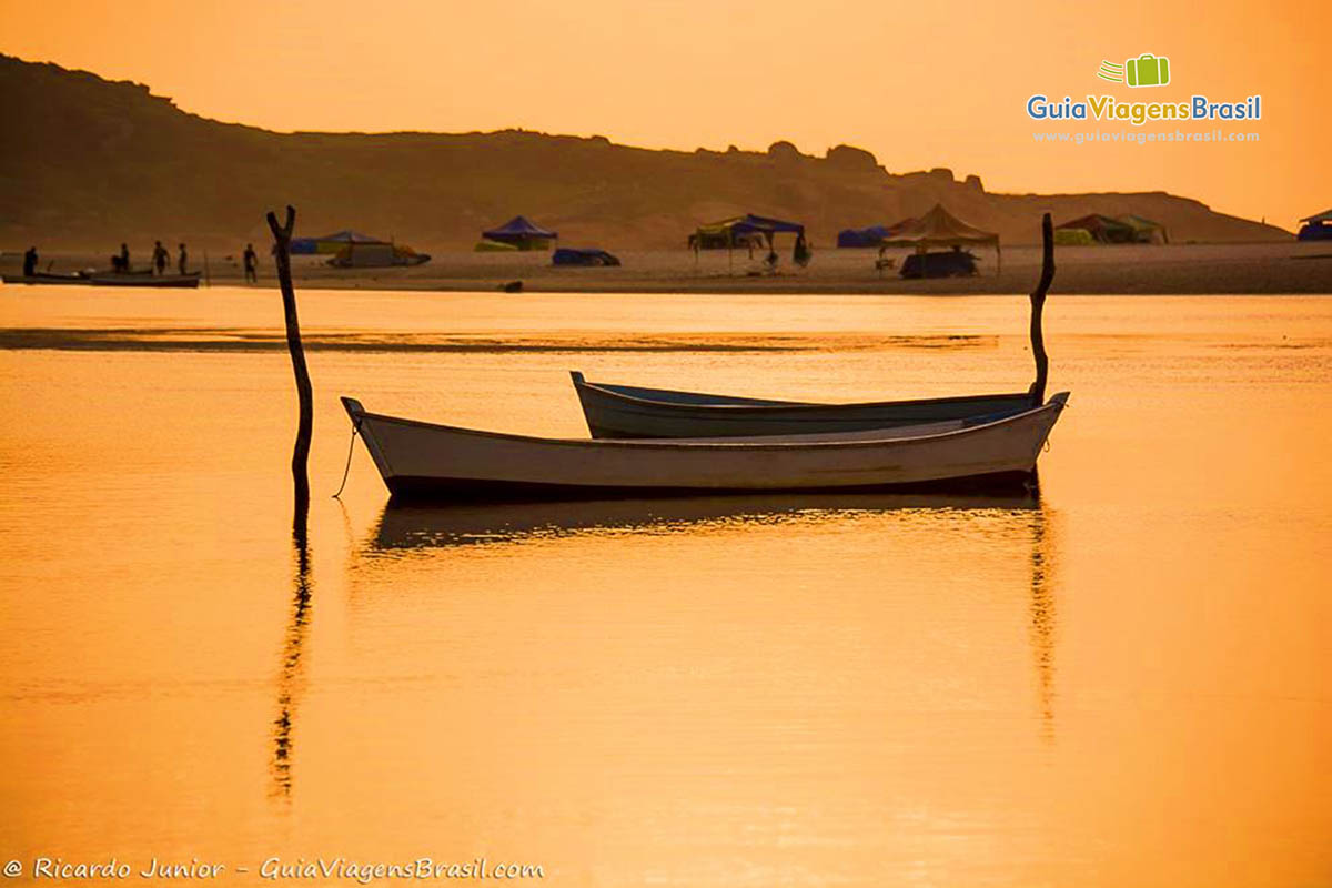 Imagem de dois barcos simples de pescador parado nas águas.