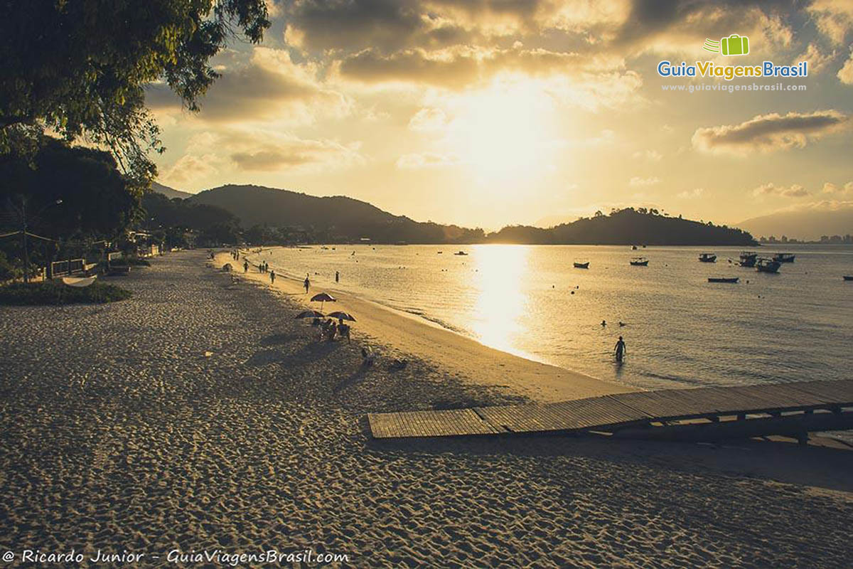 Imagem do sol refletindo nas águas no mar da Praia Central Porto Belo. 