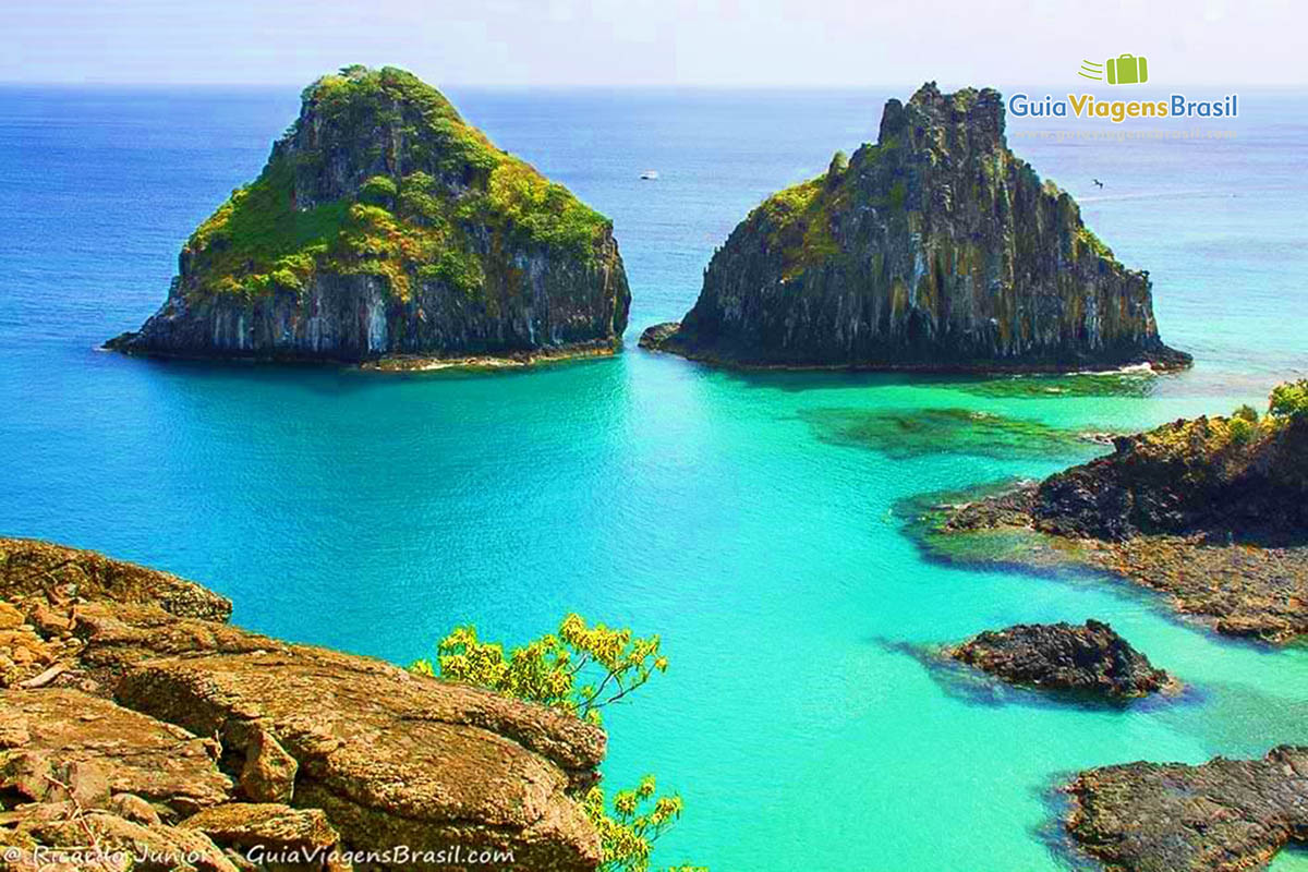 Imagem aérea da Baía dos Porcos e ao fundo duas pedras compondo a belíssima paisagem, em Fernando de Noronha, Pernambuco, Brasil. 