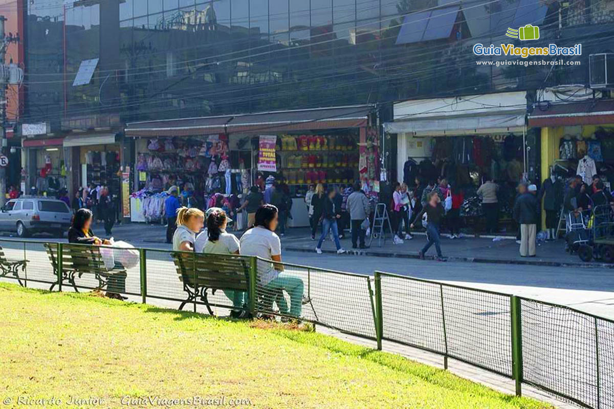 Imagem de funcionárias das lojas descansando um pouco no banco de praça,  situ