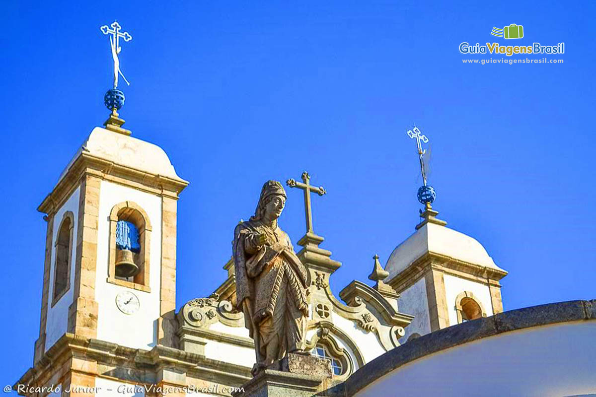 Imagem de um dos profetas e ao fundo os sinos da basílica.