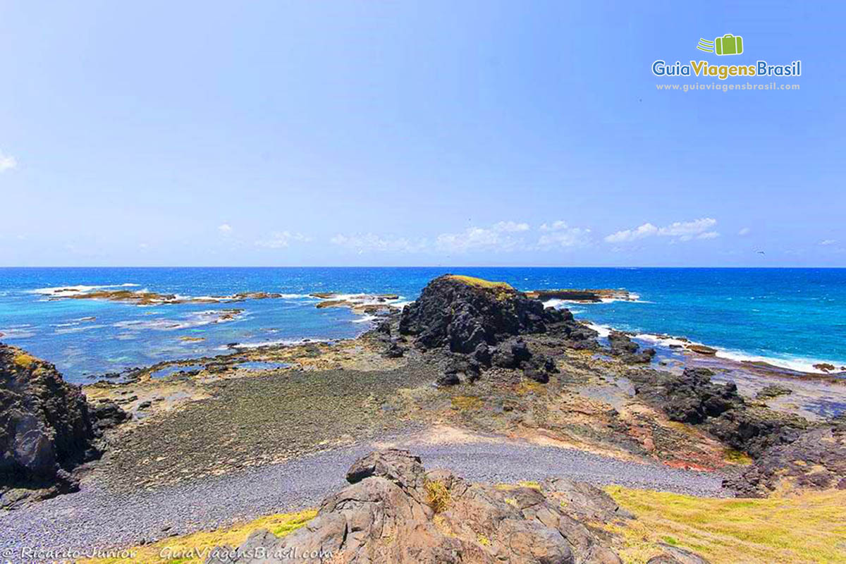 Imagem das pedras e das águas cristalinas do Buraco da Raquel, em Fernando de Noronha, Pernambuco, Brasil.