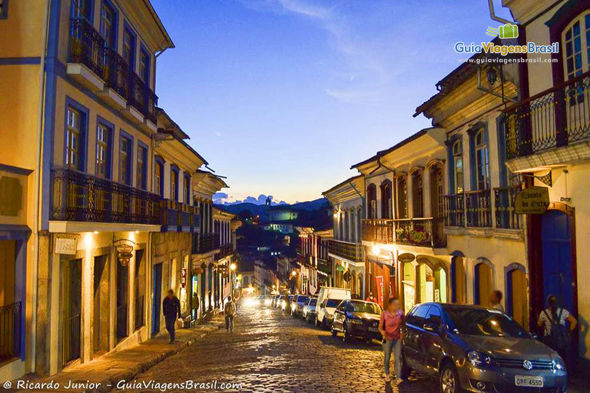 Imagem do entardecer de uma das ladeiras de Ouro Preto. Luzes das casa já acesas.