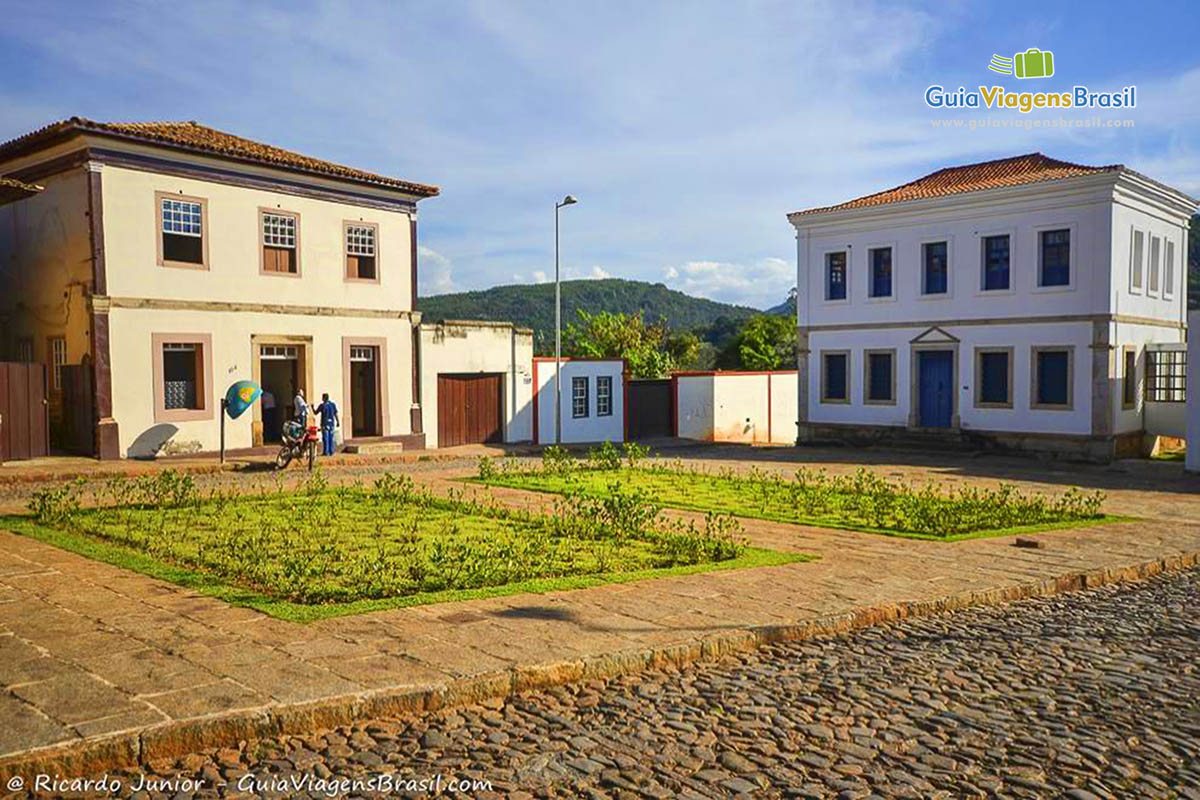 Praça com flores pequenas e dois casarões em volta, em Santa Barbara.