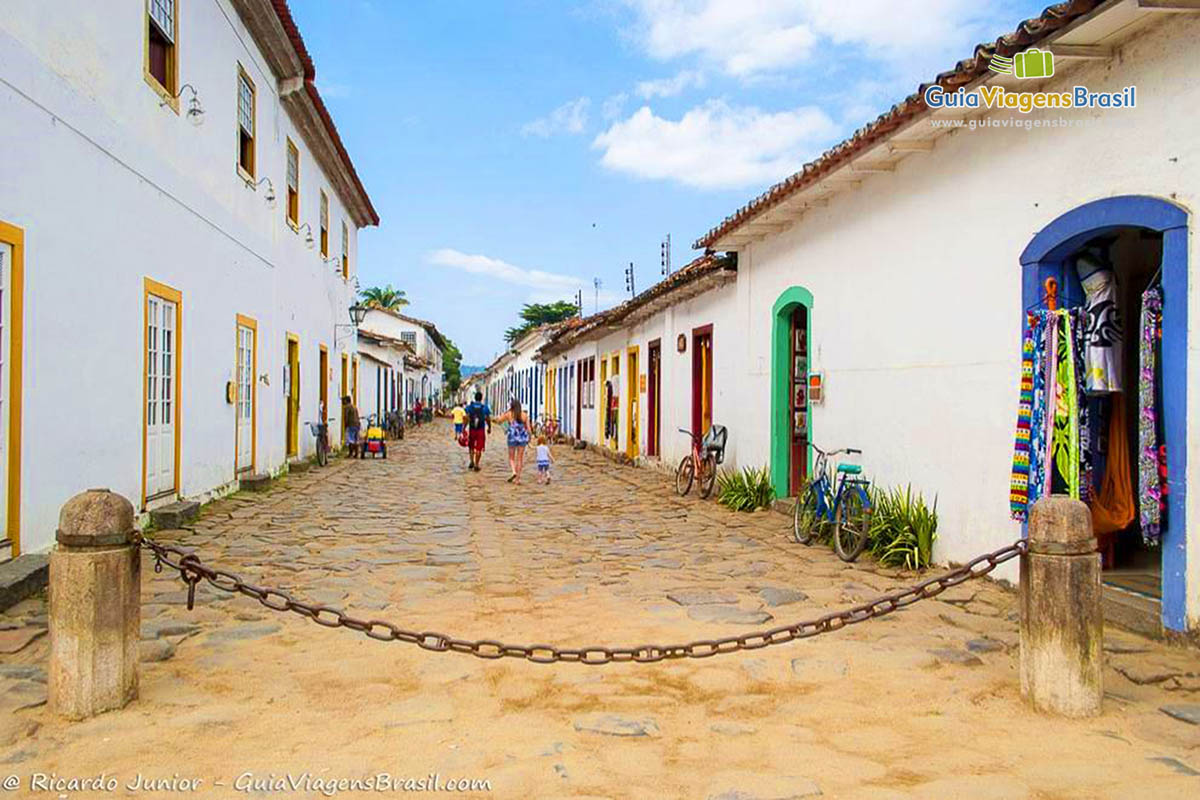 Imagem de turistas caminhando pelo calçadão do centro de Paraty.