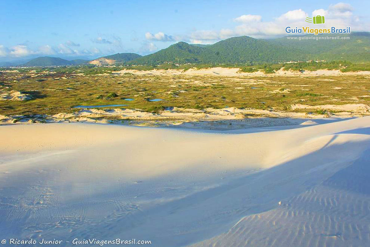 Imagem do sol batendo no topo das dunas.