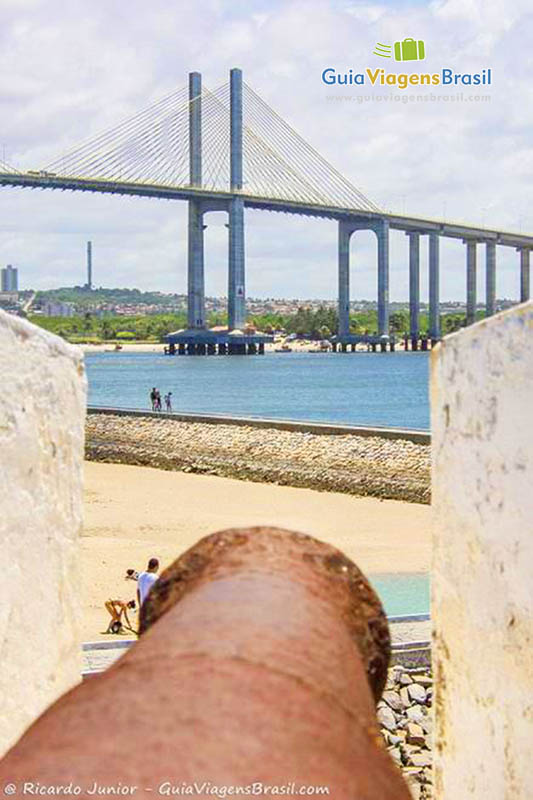 Imagem do canhão e ao fundo a Ponte Newton Navarro, em Natal.