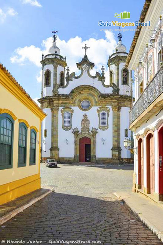 Imagem de rua estreita a ao fundo a fachada da Igreja de Nossa Senhora do Carmo.