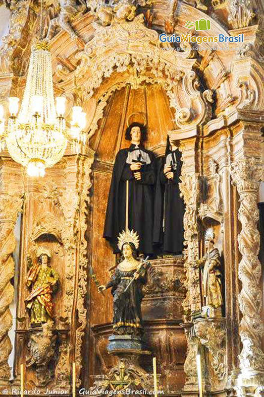 Imagem do altar com vários desenhos esculpidos na madeira.