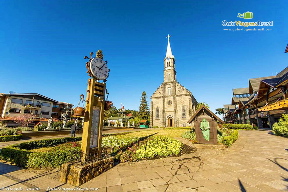 Imagem do relógio e termômetro e ao fundo a Igreja de São Pedro.