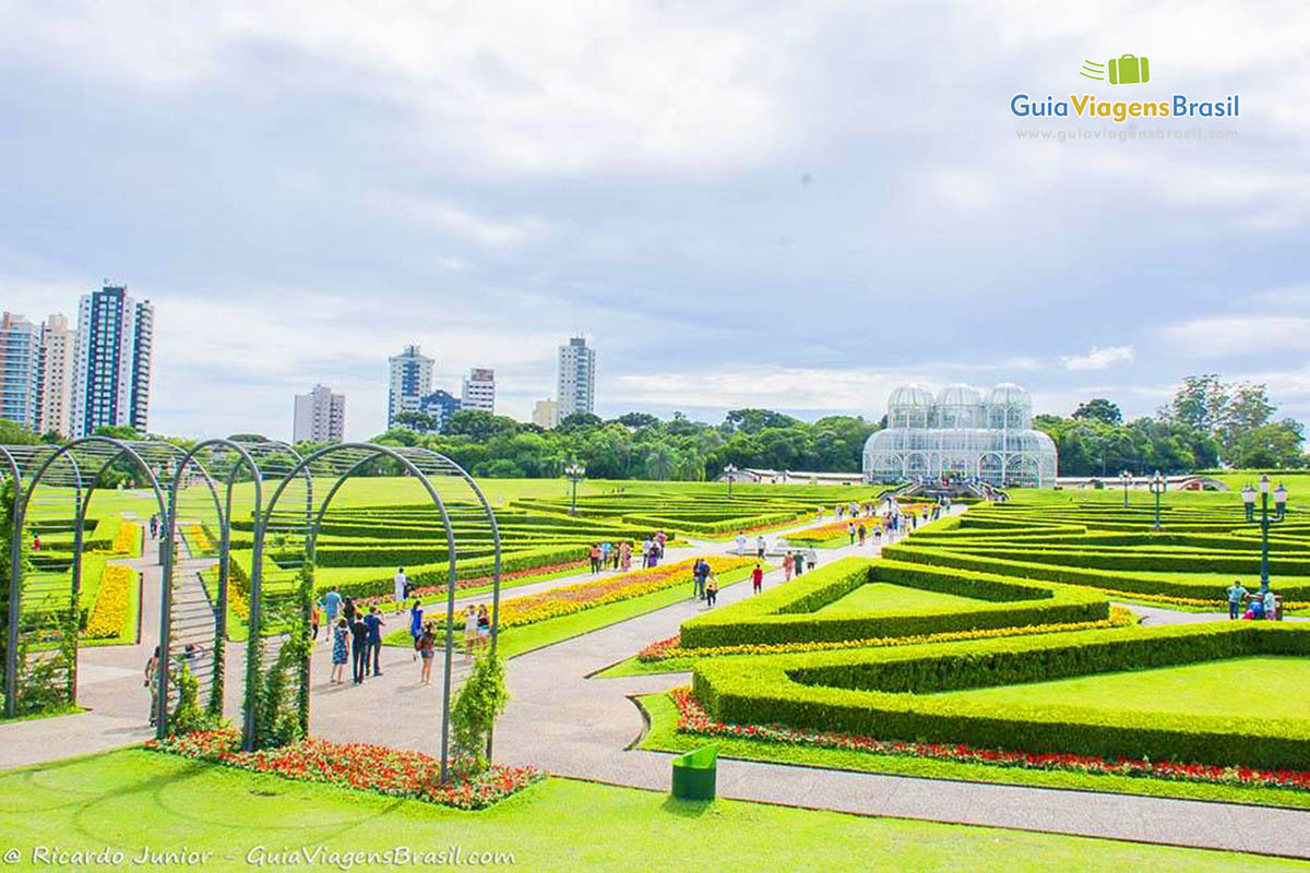Imagem ampla do imenso jardim de ao fundo a bela estufa, em Curitiba.