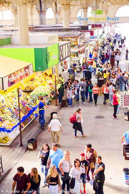 Imagem de pessoas caminhando pelos corredores do Mercado Municipal, Brasil.