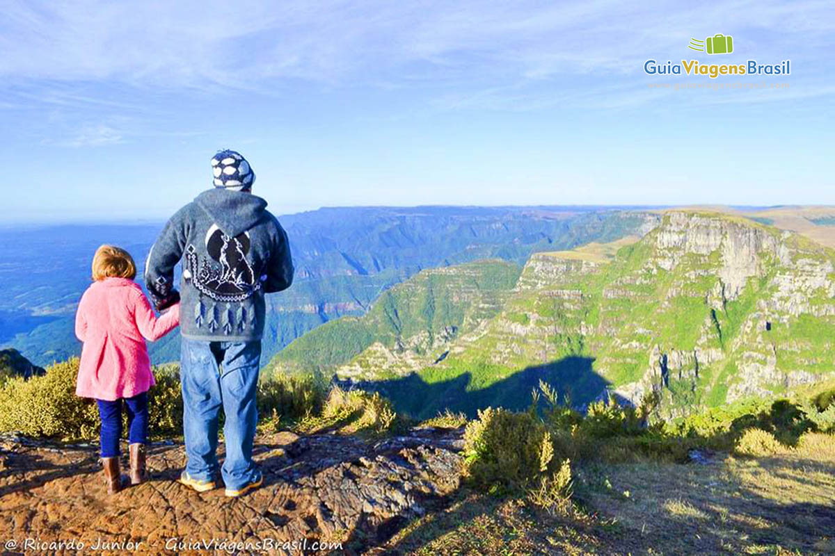 Imagem de pai e filha observando a vista encantadora.