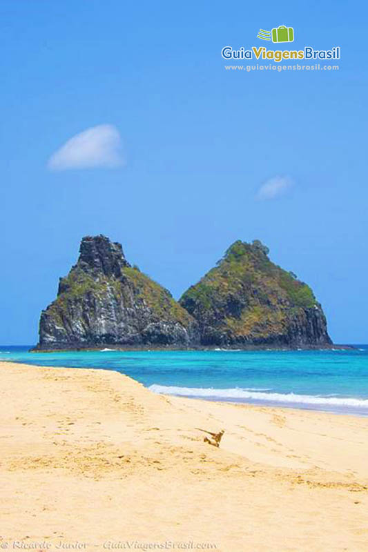 Imagem do Morro Dois Irmãos em torno as águas cristalinas da praia, em Fernando de Noronha, Pernambuco, Brasil