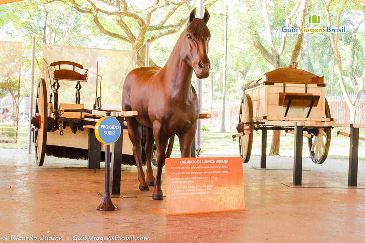 Imagem de um cavalo de madeira com uma charrete, no Museu Catavento.