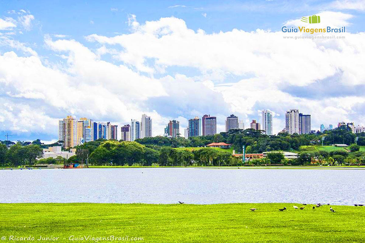 Imagem de im lago grande a ao fundo alguns prédios da cidade de Curitiba.