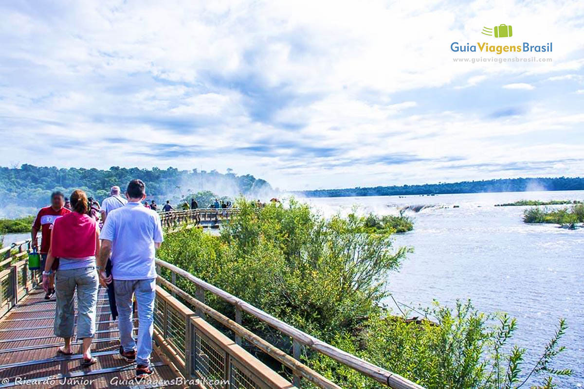 Imagem de turistas caminhando sobre a passarela já se encantando com a beleza.