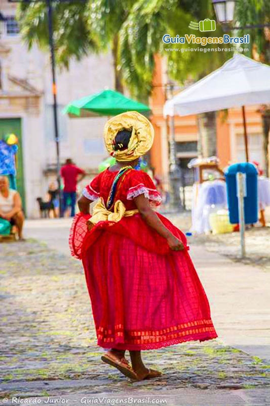 Imagem de uma baiana vestida de vermelho, no Pelourinho, Bahia.