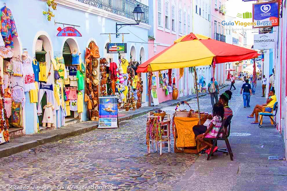 Imagem de lojas e ambulante na rua do Pelourinho, em Salvador.